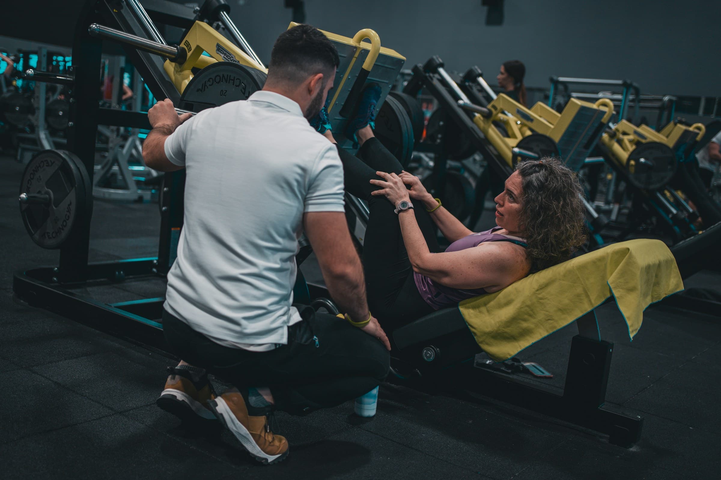 Personal trainer a acompanhar uma atleta durante o treino no ginásio
